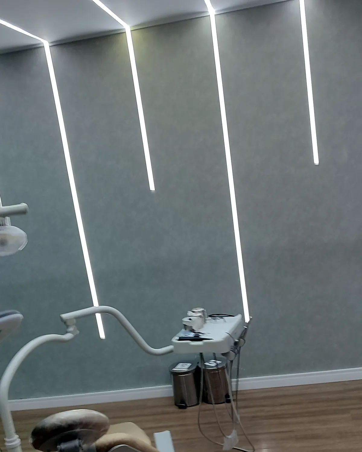 Iluminação LED linear embutida no teto e na parede de consultório