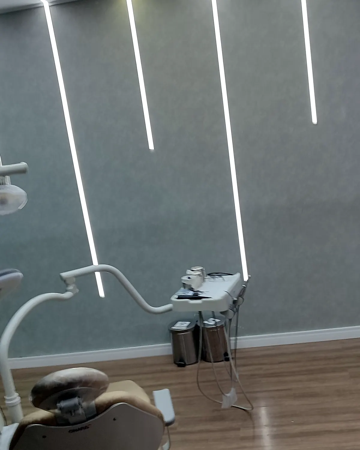 Consultório odontológico com iluminação LED linear embutida no teto e na parede