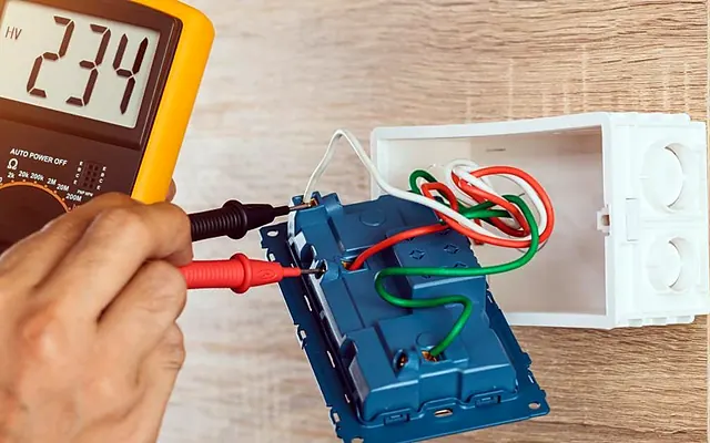 Tomada esquentando ou derretida: o que fazer (e o que não fazer) — Medição de tensão em tomada com multímetro durante manutenção elétrica residencial