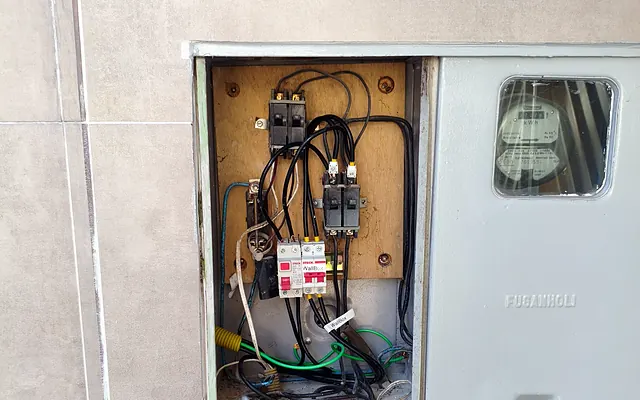 Conta de luz alta: pode ser problema na instalação elétrica? — Padrão de entrada de energia com caixa de medição e disjuntor geral embutidos no muro
