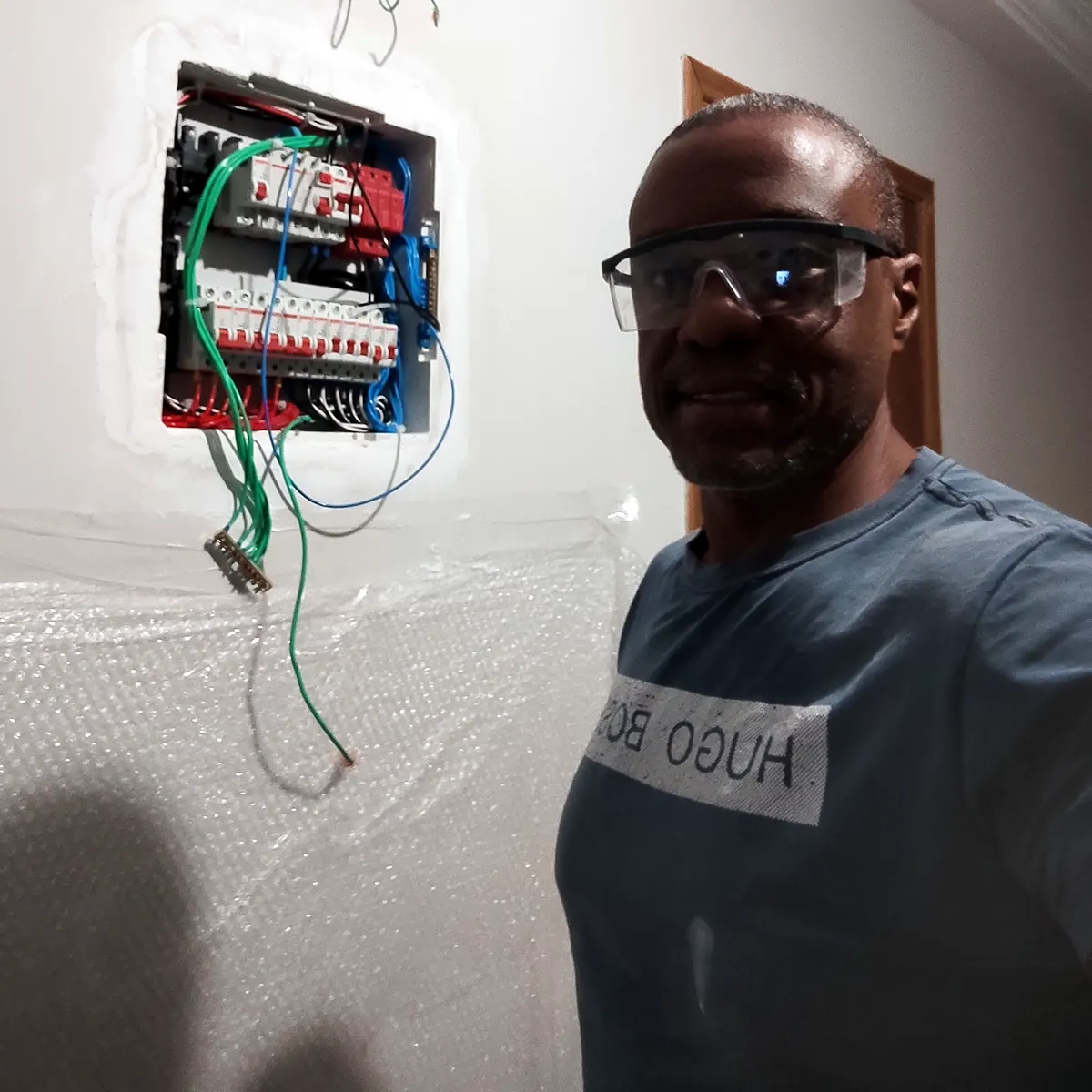 Retrofit de quadro de distribuição, com Ronaldo Américo usando óculos de proteção