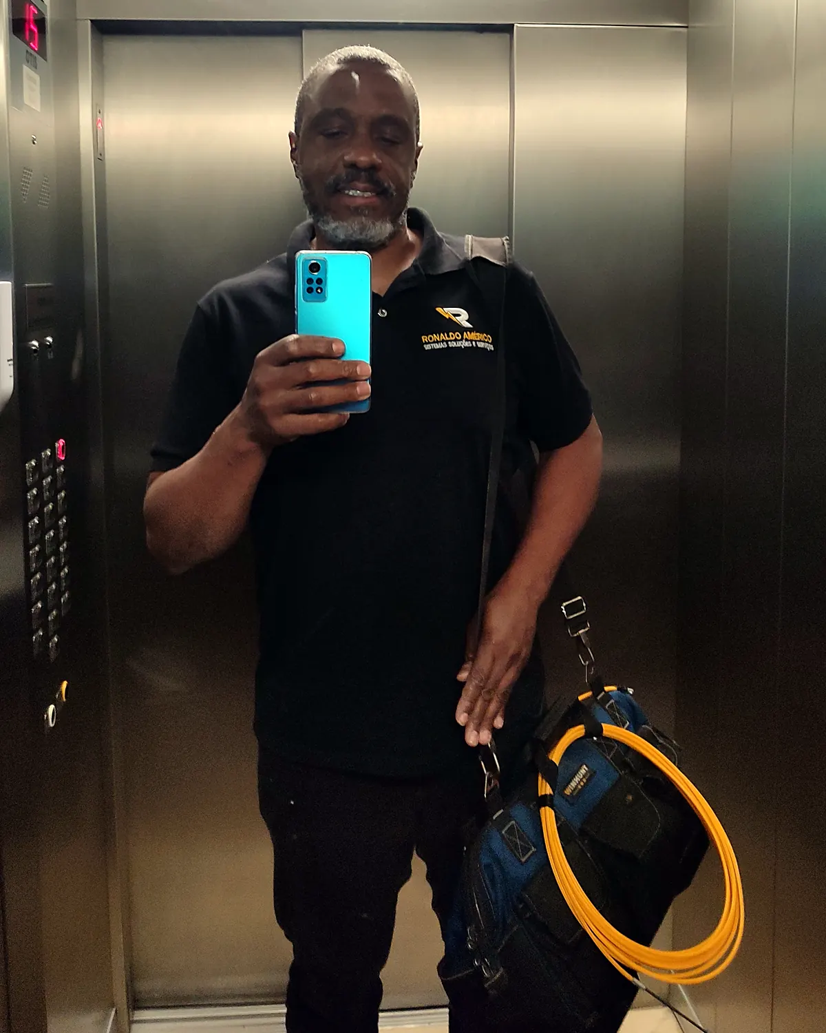 Ronaldo Américo de uniforme, com bolsa de ferramentas, a caminho do atendimento